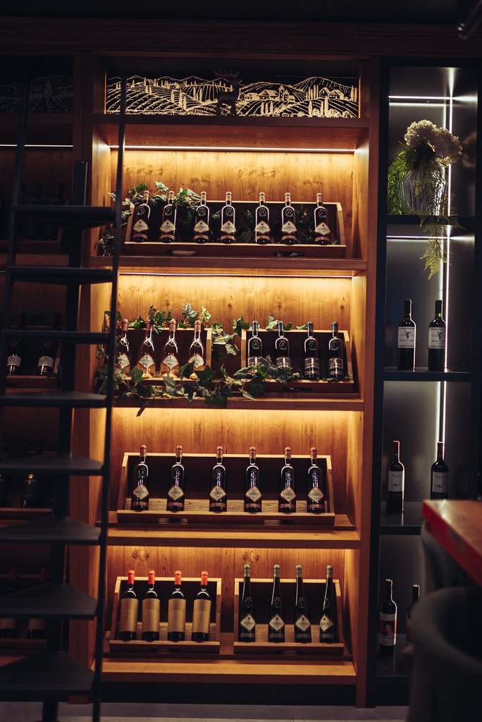 Estantería de vinos con luz cálida en el interior del bar